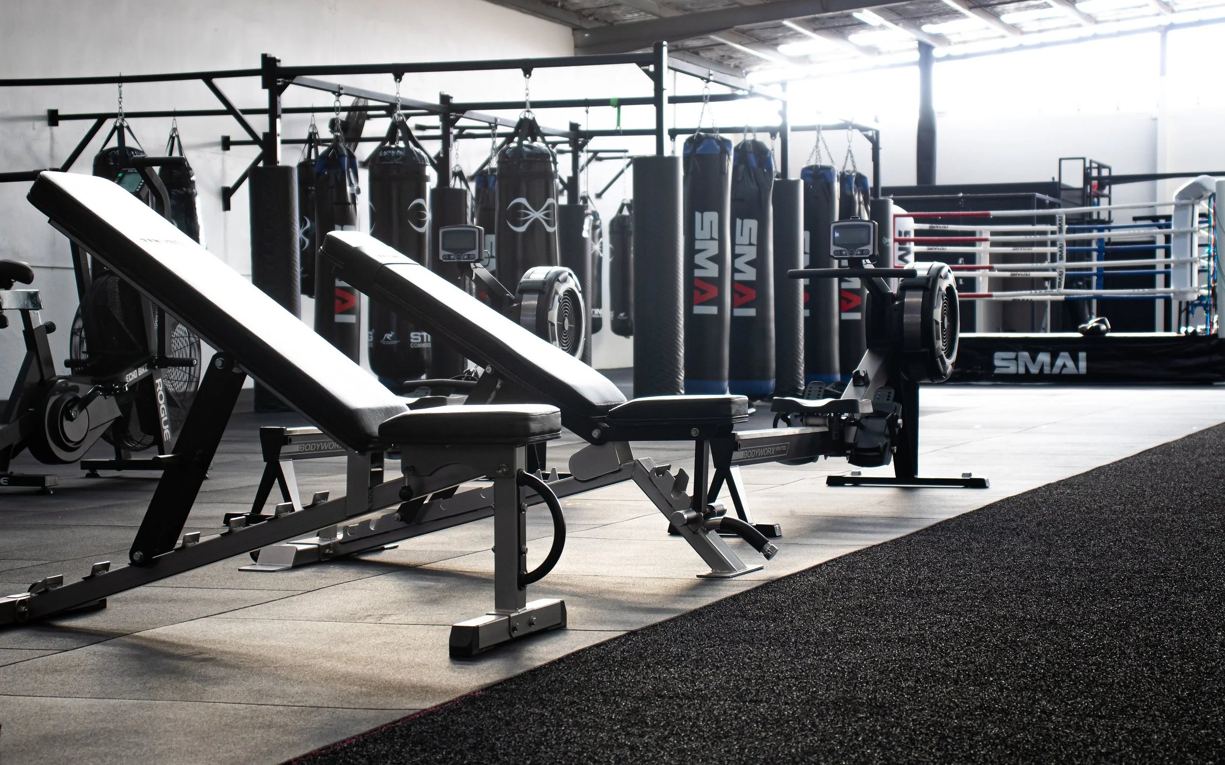Benches, rowers and the bag wall on the gym floor